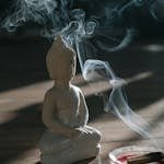 Burning Palo Santo Beside a Buddha Figurine